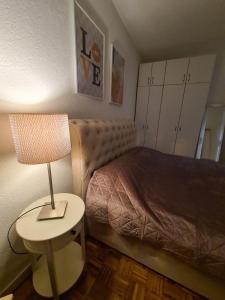 ein Schlafzimmer mit einem Bett und einer Lampe auf einem Tisch in der Unterkunft FRIENDLY HOME in Tuzla