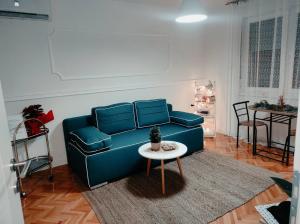 a living room with a blue couch and a table at FRIENDLY HOME in Tuzla