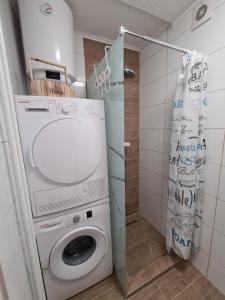 eine Waschküche mit einer Waschmaschine und einer Dusche in der Unterkunft FRIENDLY HOME in Tuzla
