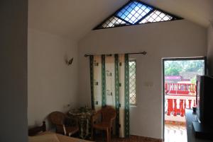 Una habitación con una mesa y sillas y una ventana. en Arjun Villa Guest House, en Anjuna 15 fotos más