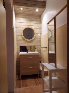 ein Bad mit einem Waschbecken und einem Spiegel in der Unterkunft Le cottage du Littoral de Petit Havre in Le Gosier