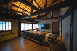 a living room with a couch and a tv in it at Castle Town Contemporary Ryokan 天籟 - TENRAI - in Takahashi