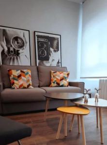 Una sala de estar con un sofá y dos mesas. en Apt nuevo! 2 hab, baño doble, garaje, Metro a 200m, en Madrid