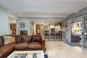 sala de estar con sofá de cuero marrón en Casa Del Mar home, en Scottsdale
