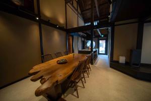 a large wooden table in a room with chairs at Castle Town Contemporary Ryokan 天籟 - TENRAI - in Takahashi
