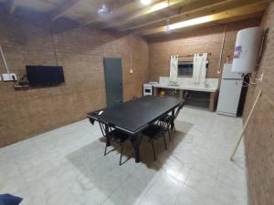 uma mesa preta e cadeiras num quarto com um frigorífico em Finca La Huella II em Santiago del Estero