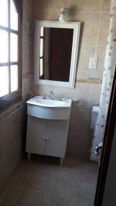 uma casa de banho com um lavatório branco e um espelho. em Alojamiento Guemes em Gualeguay