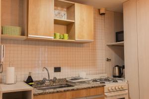 eine Küche mit Spüle und Herd in der Unterkunft Departamento Céntrico Belgrano PBE in San Carlos de Bariloche + 19 Fotos