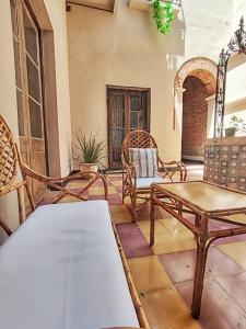 een patio met stoelen en een tafel in een kamer bij La Botica de 1852 Hotel in Chascomús