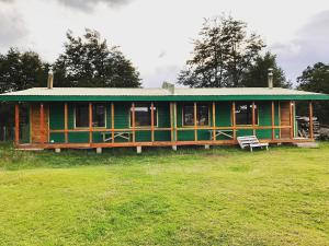a green house with a green roof in a field at Cabañas Vista al Paine in Torres del Paine