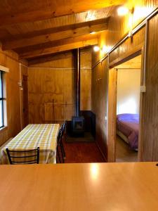 a room with a bedroom with a bed and a fireplace at Cabañas Vista al Paine in Torres del Paine