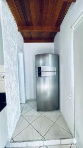 a stainless steel refrigerator in a kitchen with a ceiling at Residencial Morro do Macaco in Bombinhas