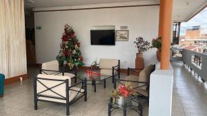 ein Wohnzimmer mit einem Weihnachtsbaum, einem Tisch und Stühlen in der Unterkunft Hotel Tayrona in Puerto Berrío