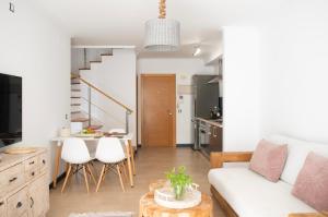 een woonkamer met een witte bank en een tafel bij Ocean View Penthouse El Cotillo in Cotillo
