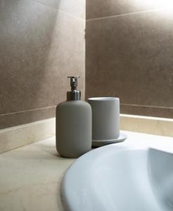 a soap dispenser sitting on top of a toilet in a bathroom at Ocean View Penthouse El Cotillo in Cotillo