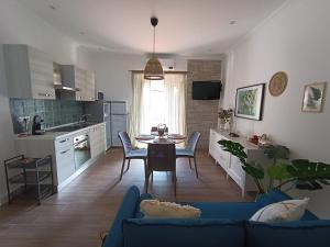 una cucina e un soggiorno con divano blu di Casa Rosamari - su Lago di Posta Fibreno, Appartamento con camino a Posta Fibreno