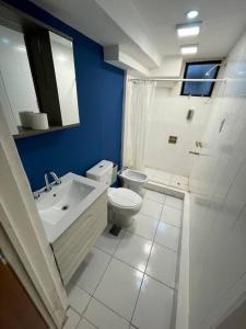 a bathroom with a white toilet and a sink at Amplia Casa cerca de Aristdes con Patio y Parilla in Mendoza