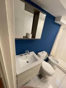 a bathroom with a sink and a toilet and a mirror at Amplia Casa cerca de Aristdes con Patio y Parilla in Mendoza +14 photos