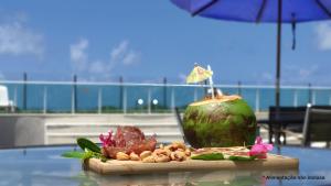 einen Tisch mit einem Getränk auf dem Tisch in der Unterkunft Areias do Mar Aconchegante e Tranquilo com Varanda in Barra de São Miguel
