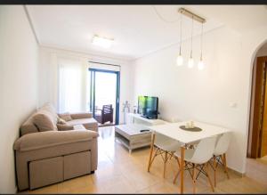 ein Wohnzimmer mit einem Sofa und einem Tisch in der Unterkunft Apartamento Galea in Santa Pola
