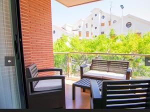 eine Terrasse mit 2 Bänken und einem Tisch auf dem Balkon in der Unterkunft Apartamento Galea in Santa Pola