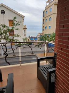 einen Balkon mit einer Bank und Straßenblick in der Unterkunft Apartamento Galea in Santa Pola