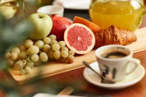 un vassoio di cibo con frutta e una tazza di caffè di Hotel Villa Schubert a Ičići