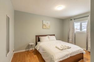 1 dormitorio con 1 cama con sábanas blancas y ventana en NN - The Woodland - Yellowknife 3-bed 1-bath, en Yellowknife