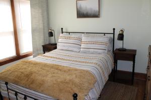 ein Bett mit einer Decke darauf in einem Schlafzimmer in der Unterkunft New 3BR near New River Gorge in Mount Hope