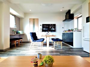 een keuken en een woonkamer met een tafel en stoelen bij GLANZ KEI Kyoto Station in Kyoto