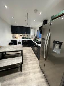 a kitchen with a stainless steel refrigerator and a table at Pembrokeshire Holiday Accommodation in Pembrokeshire