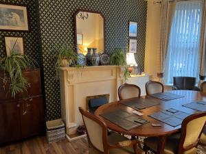 a dining room with a table and a fireplace at Cosy Town House in Belfast