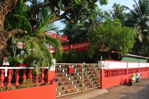 una motocicleta estacionada frente a una valla roja en Arjun Villa Guest House, en Anjuna