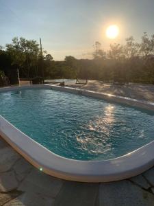 una piscina con puesta de sol en el fondo en Sítio Santa Rita, en Prados