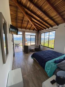 a bedroom with a bed and a flat screen tv at Glamping Esmeralda in San Gil