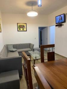 ein Wohnzimmer mit einem Sofa und einem Tisch in der Unterkunft Villa Flor 2022 in Los Plátanos