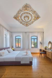 a large bedroom with a large bed and a chandelier at Eressian Hotel & Hammam Spa in Eresos