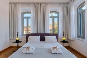 a bedroom with a bed with two pillows and two windows at Eressian Hotel & Hammam Spa in Eresos