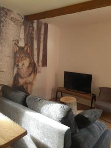 ein Wohnzimmer mit einem Wolfgemälde an der Wand in der Unterkunft CASTEL ISARD - Le Refuge in Porté-Puymorens