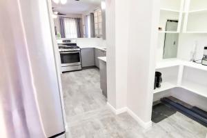a kitchen with white walls and wooden floors at Vacation Home Minutes From Downtown, Great For Families in Ogden