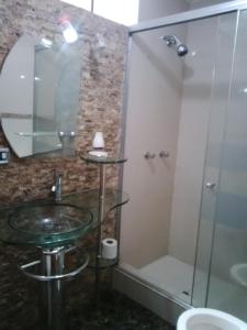 uma casa de banho com um lavatório de vidro e um chuveiro em Departamentos Las Lilas Surco Lima em Lima