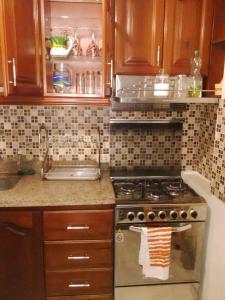 a kitchen with wooden cabinets and a stove top oven at Departamentos Las Lilas Surco Lima in Lima