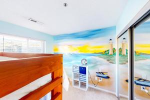 ein Schlafzimmer mit einem Wandbild eines Strandes und eines Leuchtturms in der Unterkunft Playa Rana 312 in Virginia Beach