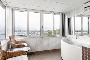 bagno con vasca, sedie e finestre di Best Western Hotel Corallen a Oskarshamn