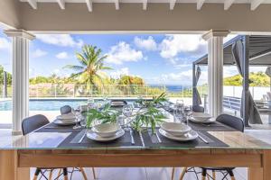 a dining room with a table and a view of the ocean at VILLA MELINA in Cadet