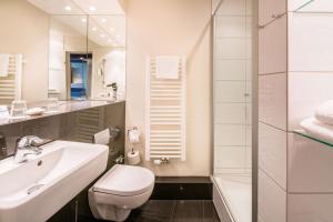 ein Bad mit einem Waschbecken, einem WC und einer Dusche in der Unterkunft Best Western Hotel Hamburg International in Hamburg