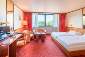 Habitación de hotel con cama grande y escritorio. en Best Western Hotel Hamburg International, en Hamburgo