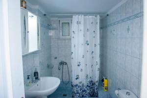 łazienka z zasłoną prysznicową i umywalką w obiekcie Stefkas apartment2 w mieście Patras