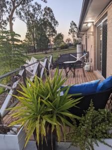 un patio con sofá y una mesa en una terraza en Scenic Sunsets@Tamborine en Tamborine