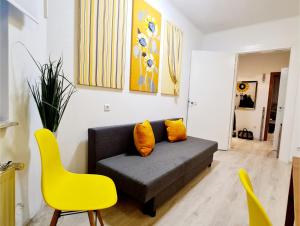 ein Wohnzimmer mit einem Sofa und einem gelben Stuhl in der Unterkunft ELENA flat Sonnenblumen Duisburg Zentrum in Duisburg